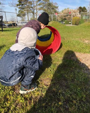 Et billede af et barn der er på vej ind i en legetunnel